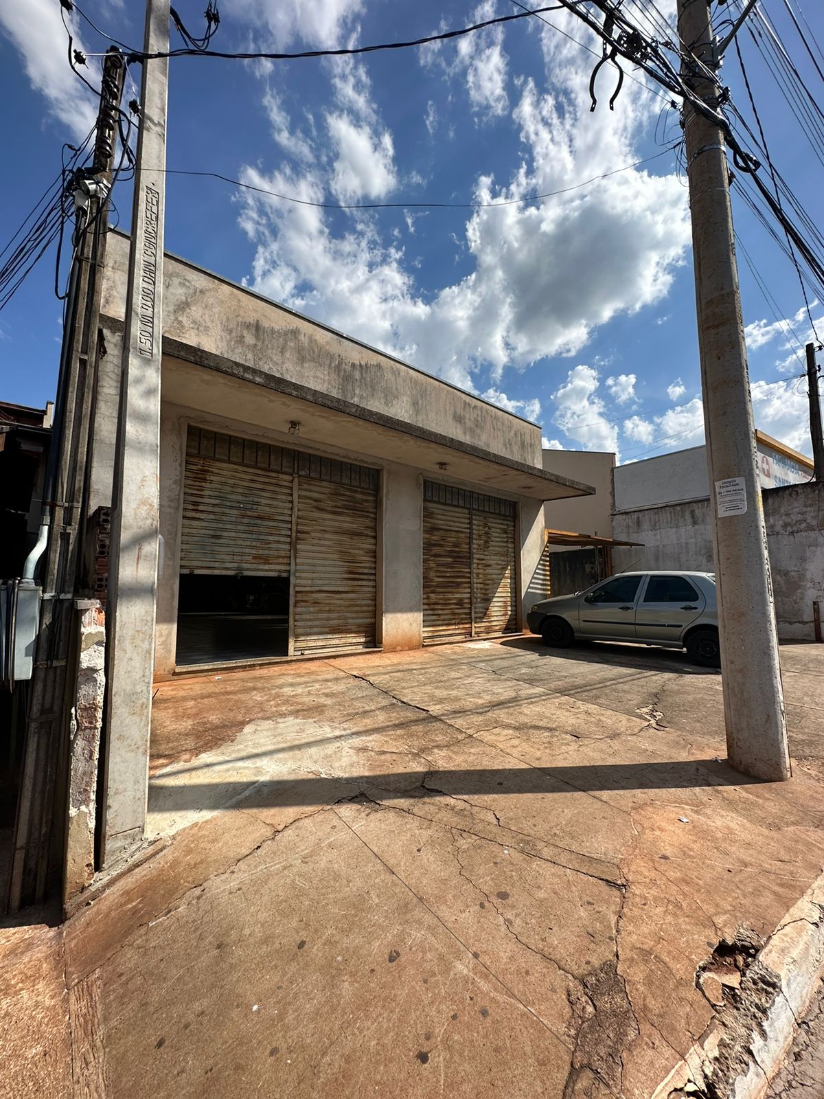 Fachada do Santo Fogo antes da reforma — porta de aço enferrujada, parede cinza manchada
